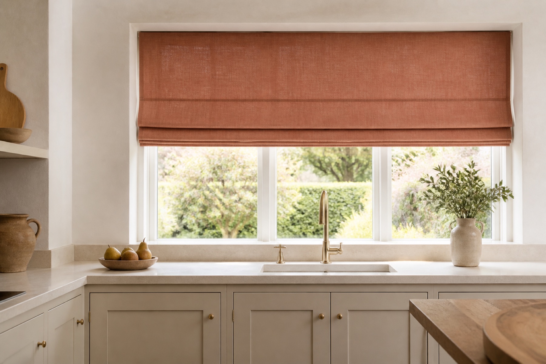 Muted terracotta Roman blind above a bright modern kitchen sink
